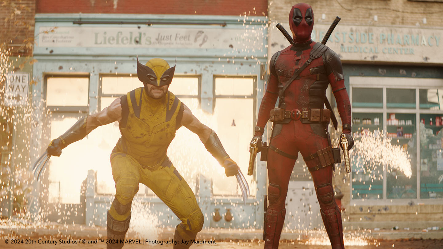 Wolverine & Deadpool on street surrounded by explosion sparks